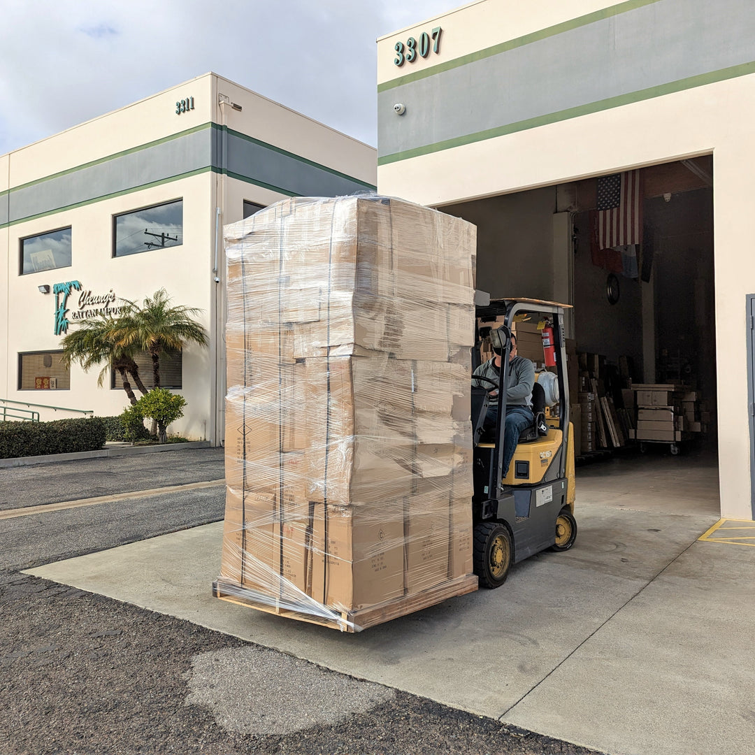 A forklift moving a pallet outside of a building.