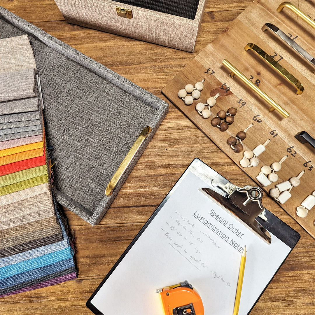 A picture of a table with a tray, a cloth swatch, and handle swatch, and a note pad used to take custom orders.